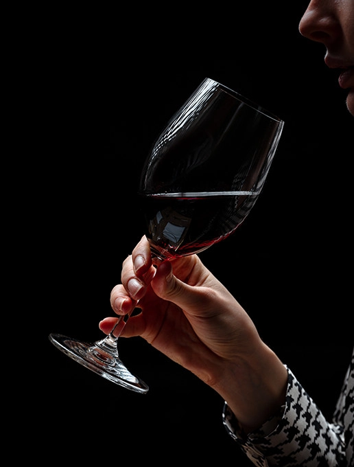 A young woman enjoying a glass of wine in a cosy atmosphere to celebrate Christmas at Dans le Noir ? restaurant.