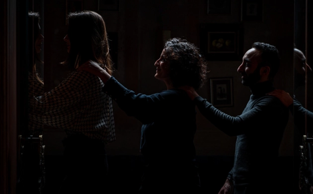 Clients formant une file en se guidant par l'épaule, découvrant l'expérience immersive du restaurant Dans le Noir ? avant de dîner dans l'obscurité totale.