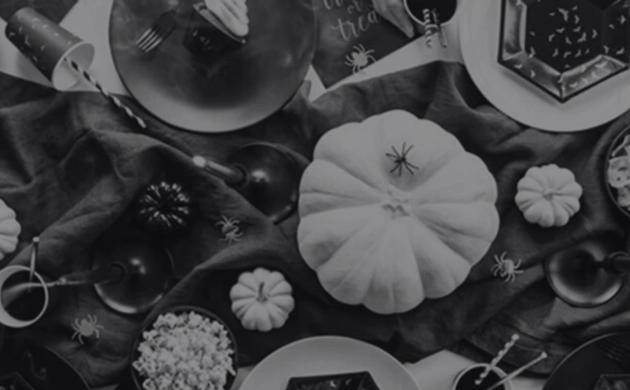 Table décorée pour Halloween avec citrouilles, araignées décoratives et gourmandises aux couleurs de la fête.